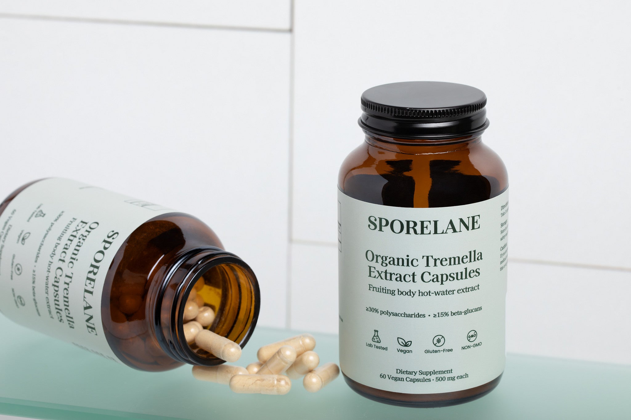 Open bottle of Sporelane Organic Tremella Extract Capsules with vegan capsules spilled beside the product